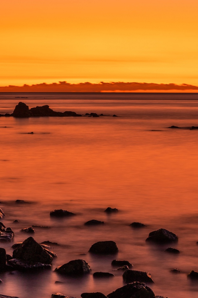 Камни на берегу моря на закате в сумерках 