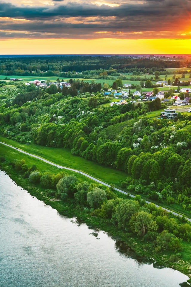 Закат солнца над городом у реки, вид с высоты 