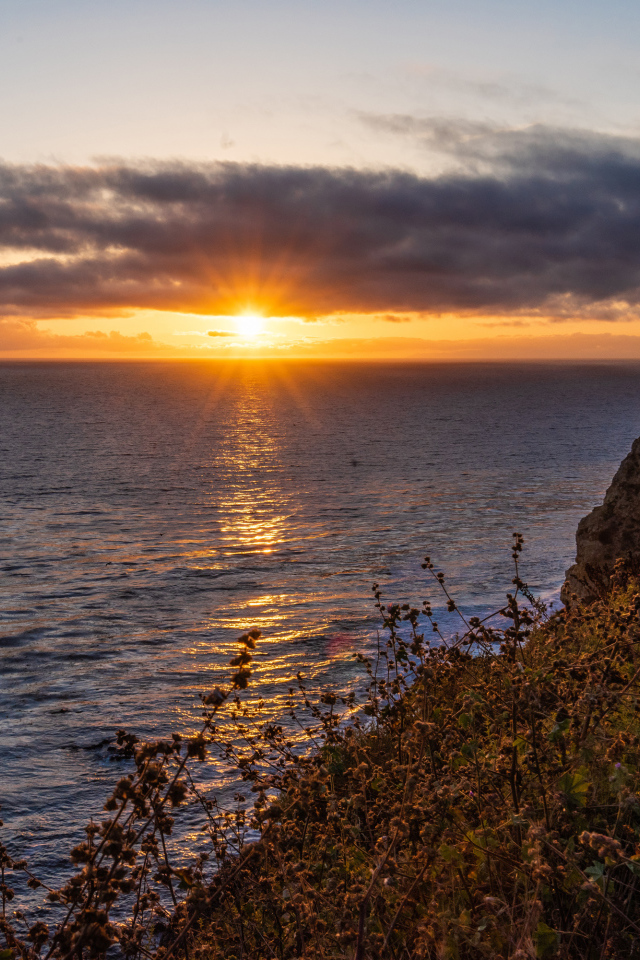 Вид на закат солнца в темных облаках в небе над морем 