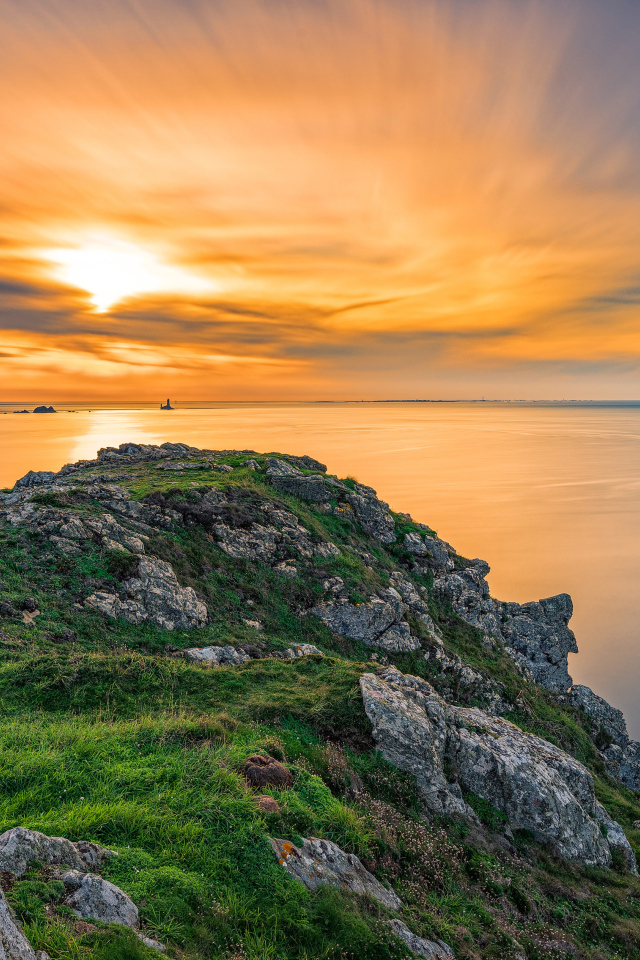 Вид со скалы на красивый закат в небе над спокойным морем 