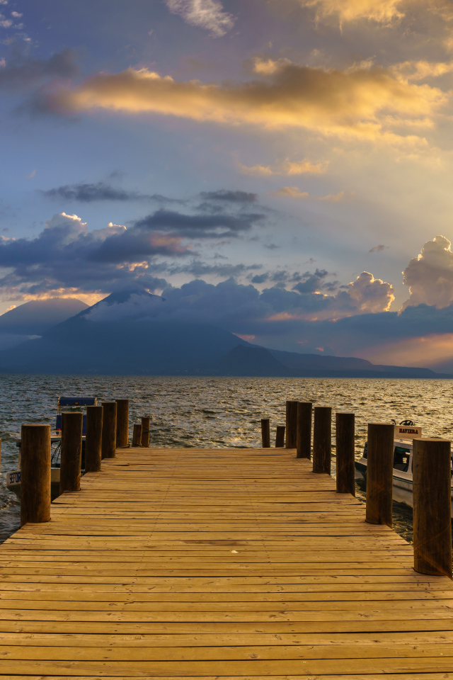 Деревянный мост в море на закате солнца 