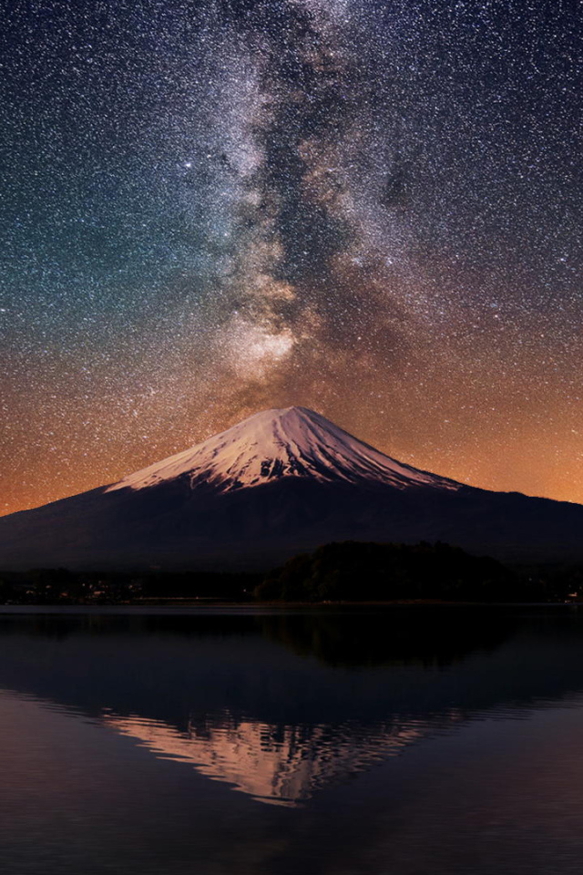 Заснеженная вершина вулкана под звездным небом