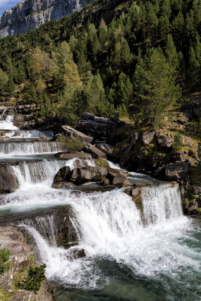 Красивые каскады водопада у скалы 