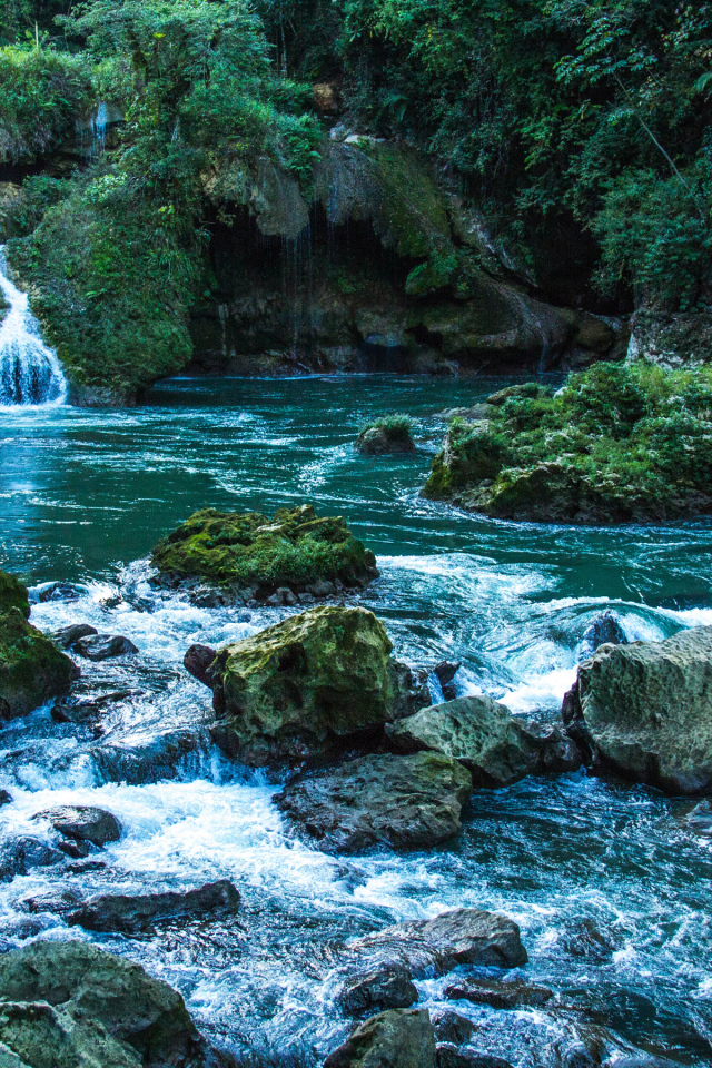 Голубая вода в водопаде стекает по камням 