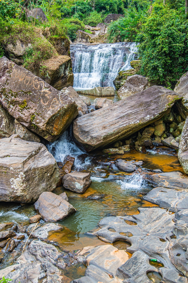 Лесной водопад стекает по огромным камням