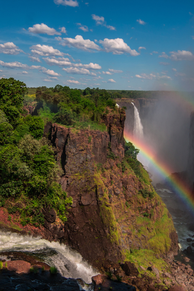 Радуга над водопадом на утесе 