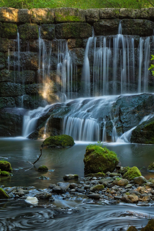 Водопад пробивается сквозь покрытые мхом камни 