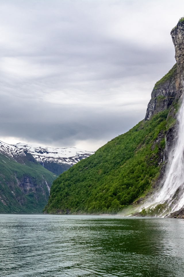 Водопад стекает с утеса в озеро, Норвегия