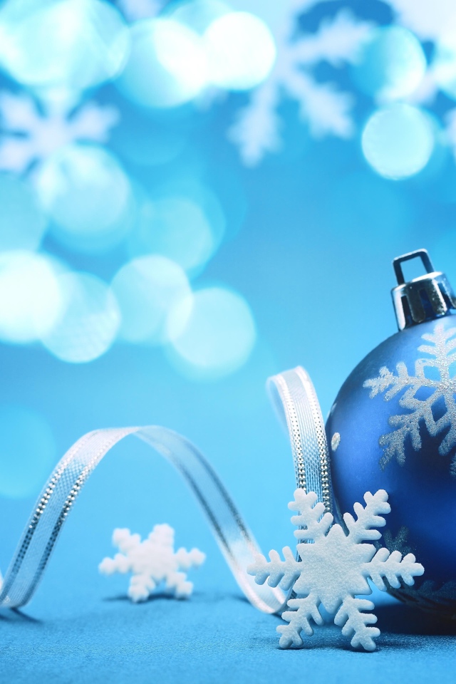 Красивый синий елочный шар с лентой и снежинками на Новый год 