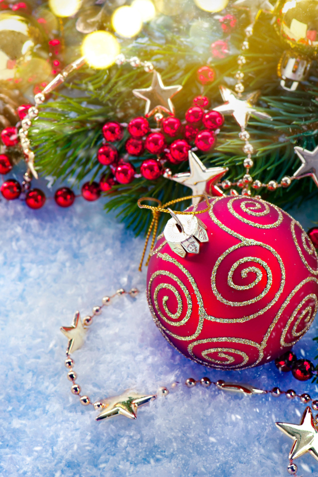 Яркие елочные украшения на снегу с веткой 