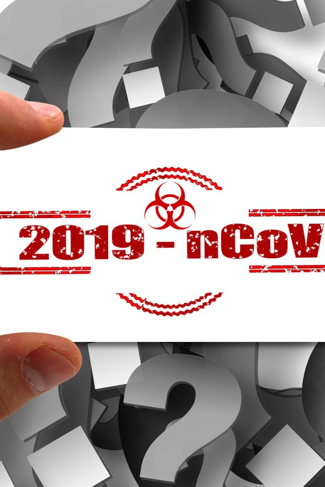 Табличка коронавирус covid-19 в руке на фоне знаков вопроса