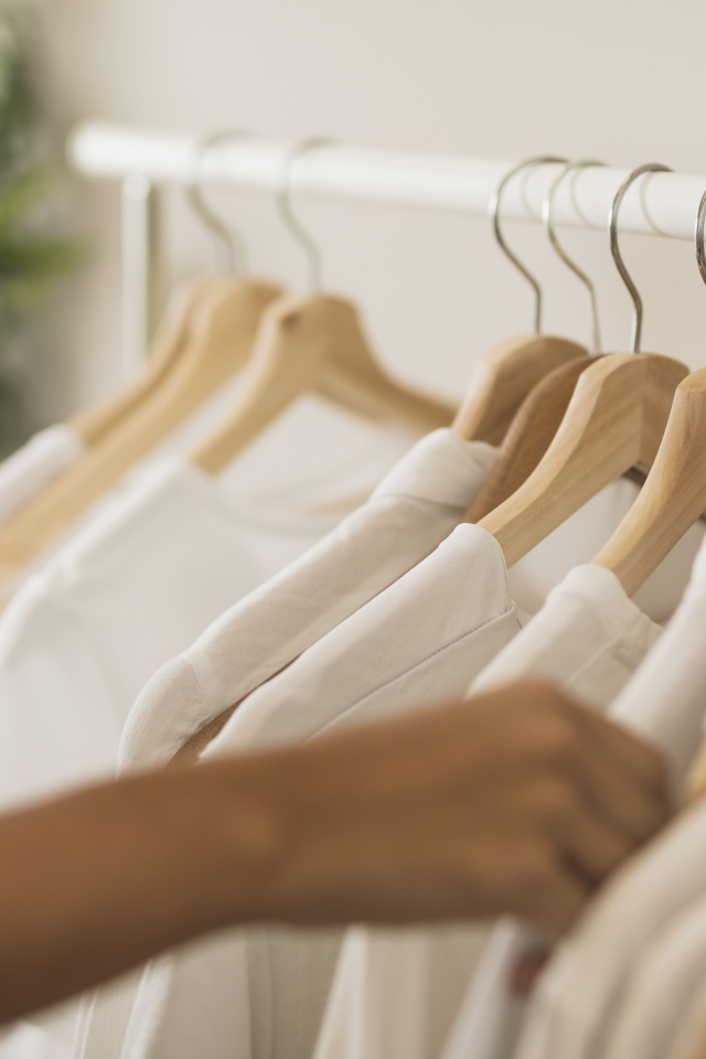 Много белых рубашек на вешалке