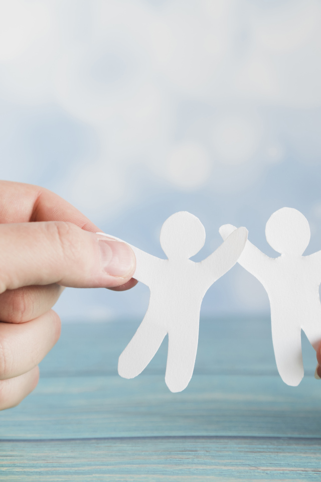 Два бумажных человечка в руках 