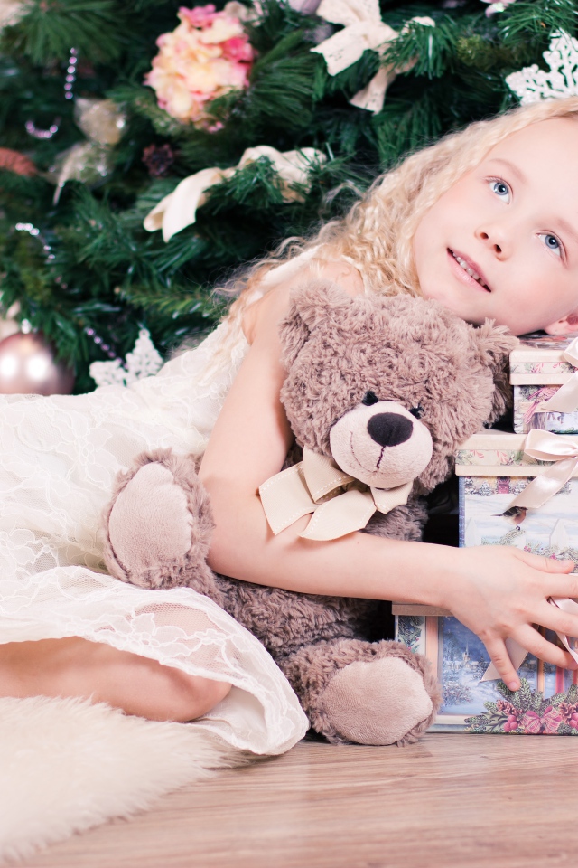 Красивая голубоглазая девочка с подарками у елки