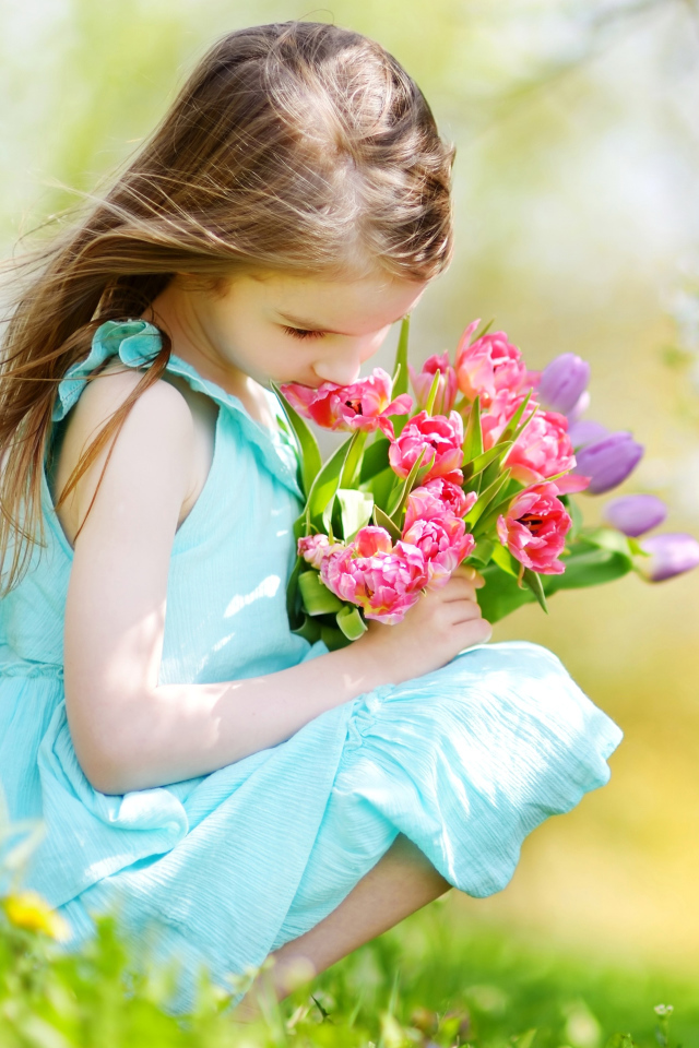 Красивая девочка в голубом платье с букетом тюльпанов