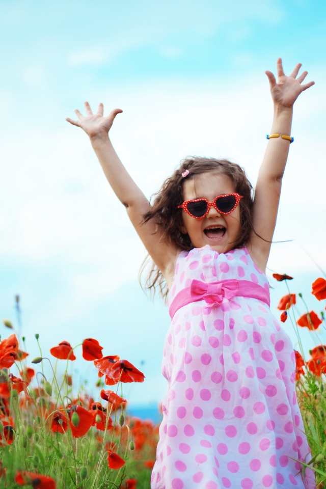 Счастливая маленькая девочка в платье на поле с маками