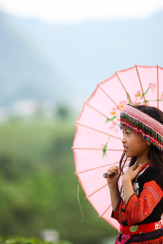 Маленькая девочка азиатка в розовым зонтом