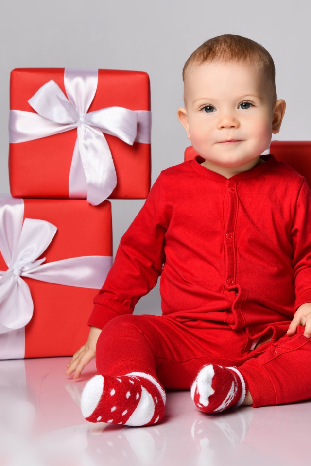 Маленький мальчик в красном костюме с подарками
