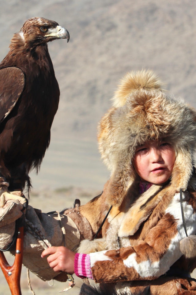 Маленький ребенок на охоте с хищным орлом