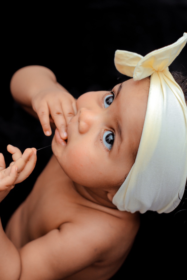 Маленькая темноволосая девочка с бантом на голове 