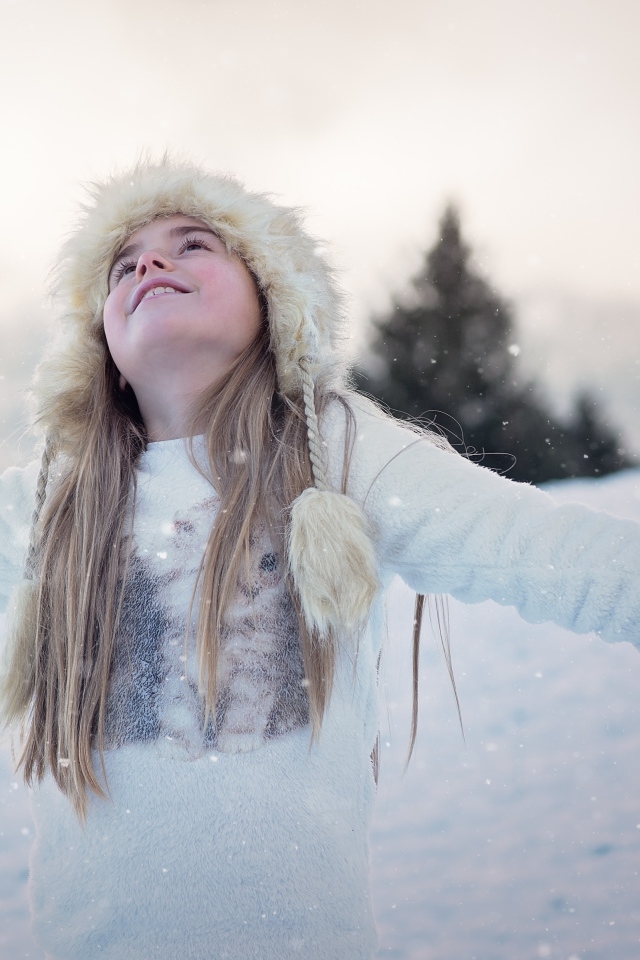Маленькая девочка в теплой шапке на улице зимой
