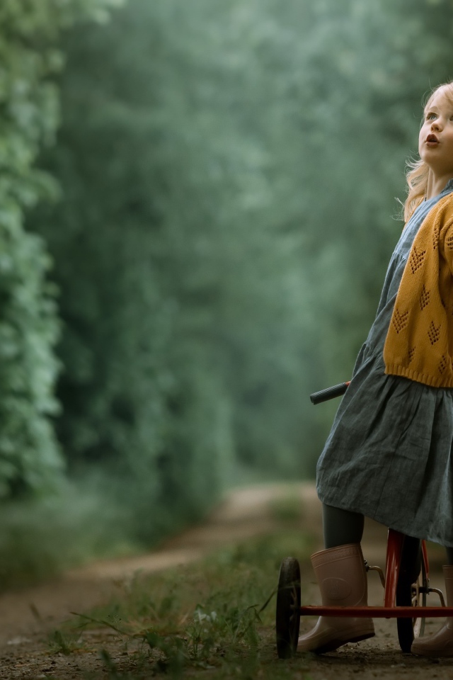 Маленькая девочка на трехколесном велосипеде 