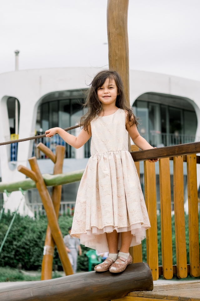 Маленькая девочка стоит на детской площадке 