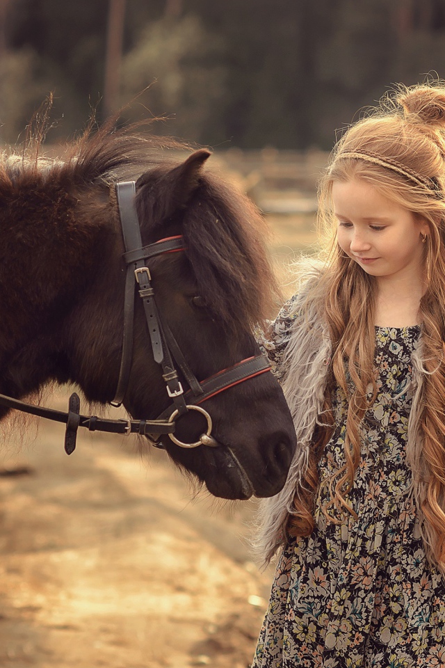 Маленькая девочка с пони на ферме