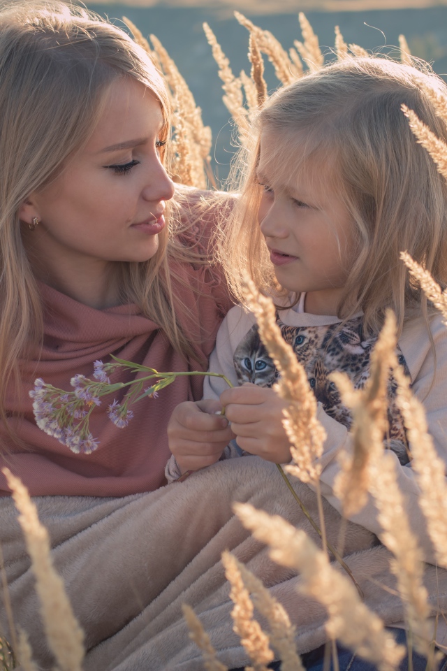 Маленькая девочка с мамой на поле с колосками 
