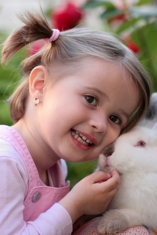 Маленькая улыбающаяся девочка с белым кроликом