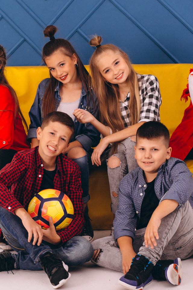 Много модных школьников сидят на диване