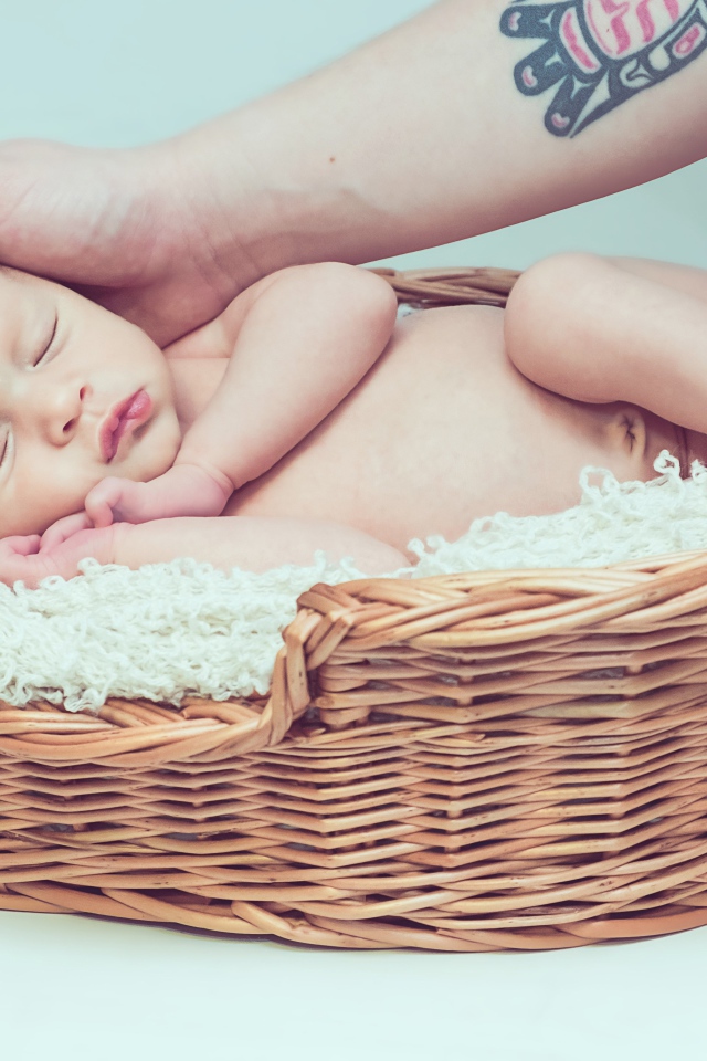 Спящий грудной ребенок в корзине на сером фоне 