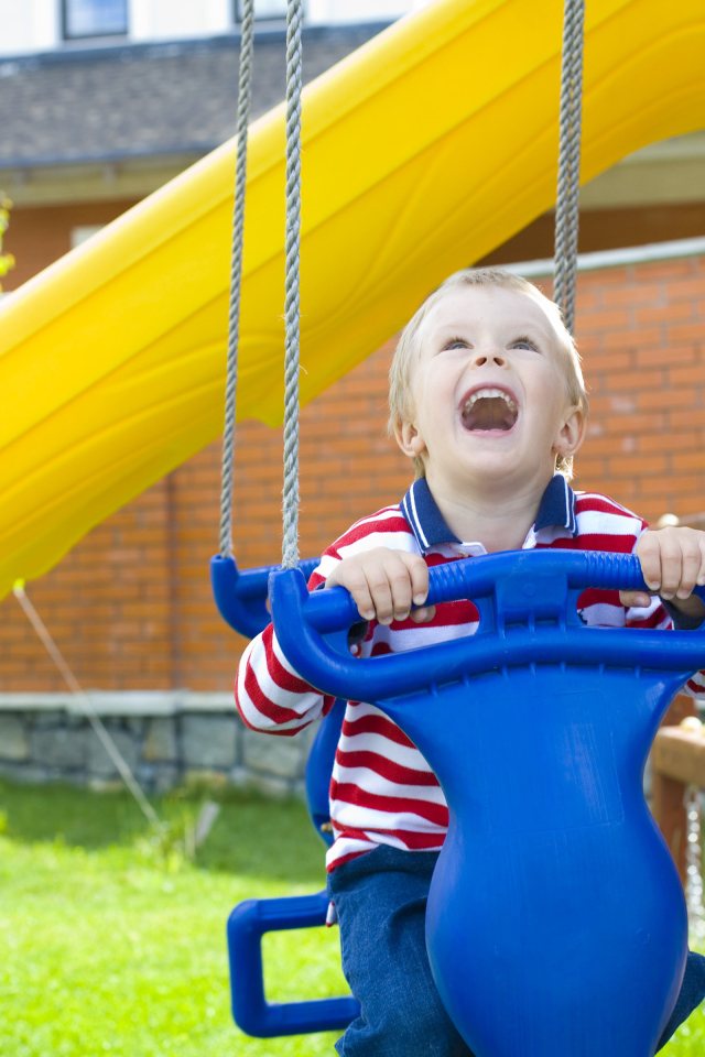 Улыбающийся ребенок на качели 