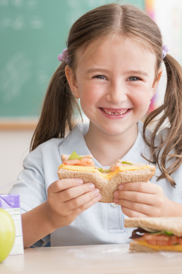 Улыбающаяся девушка школьница в столовой 