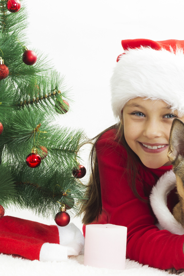 Улыбающаяся девочка с собакой у зеленой елки