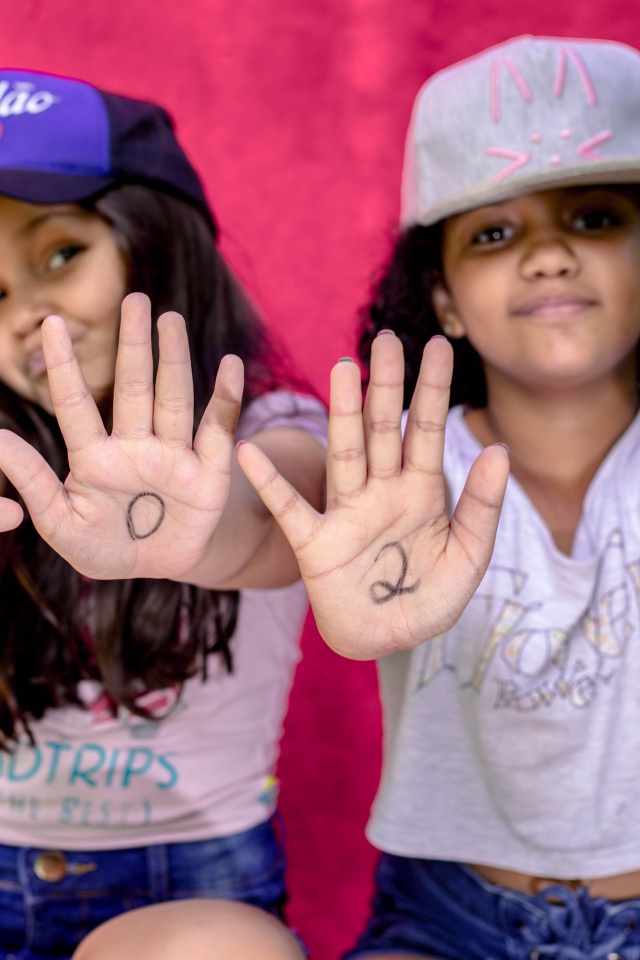 Две маленькие девочка с цифрами на ладонях 