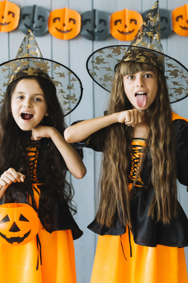 Две маленькие девочки в костюмах ведьмы на Хэллоуин