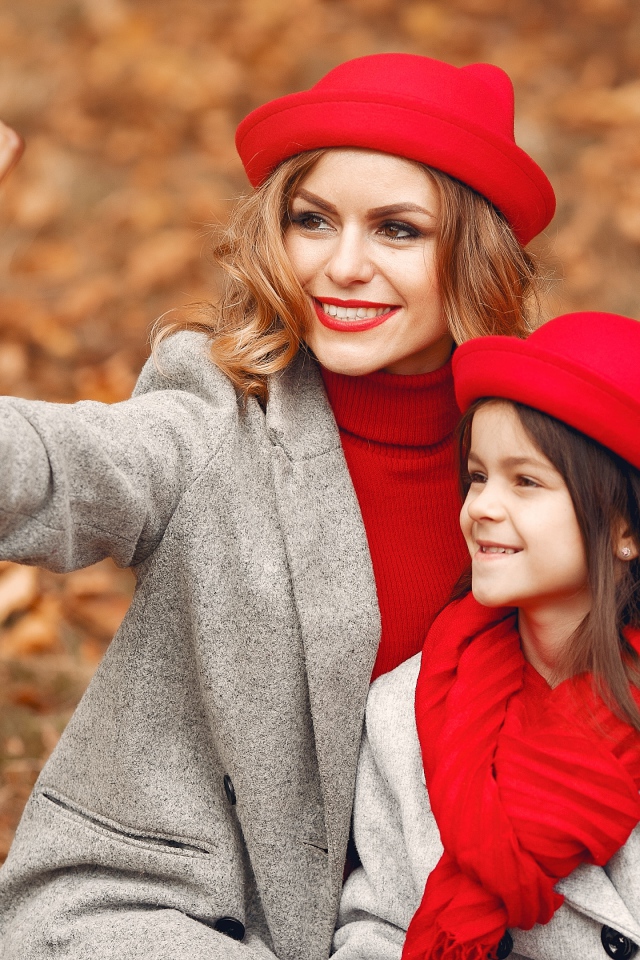 Женщина с маленькой девочкой делают селфи в лесу 