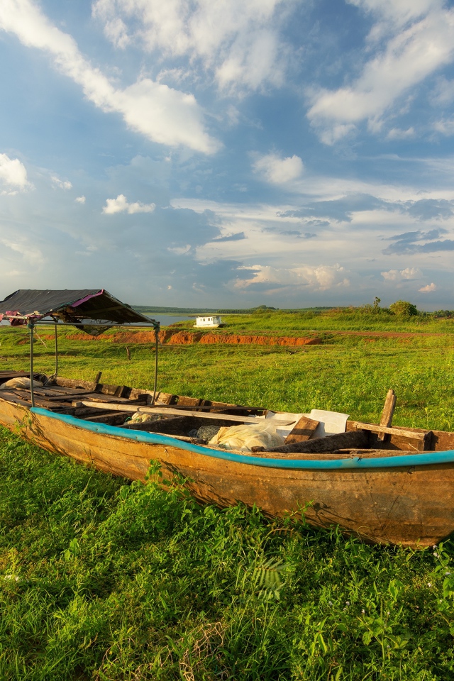 Большая деревянная лодка на зеленой траве
