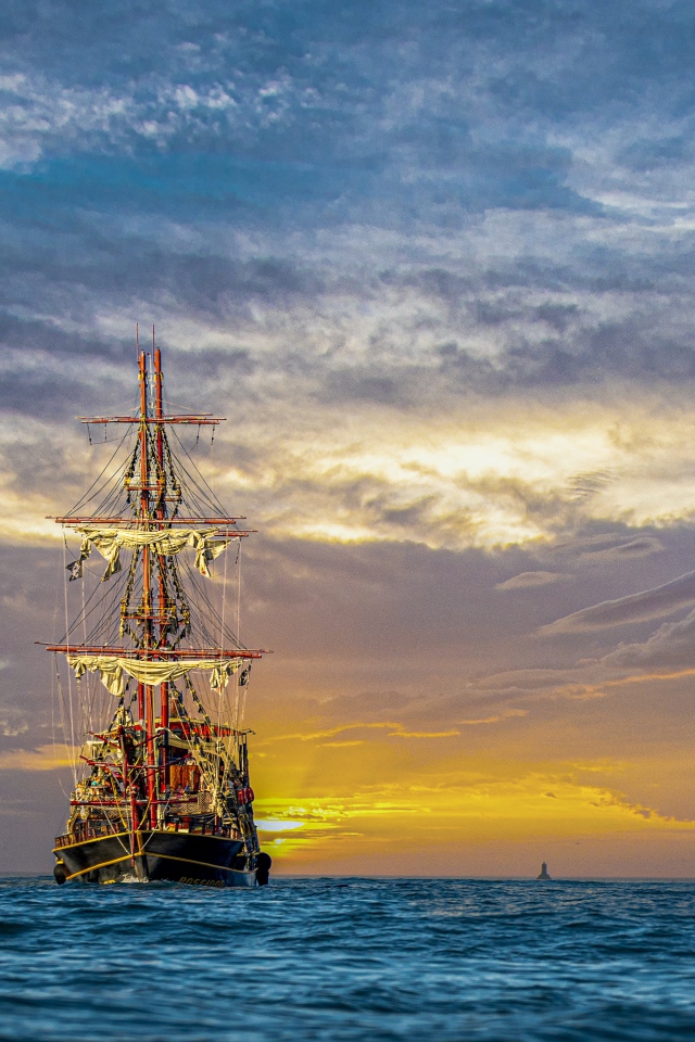Large pirate ship at sea at sunset