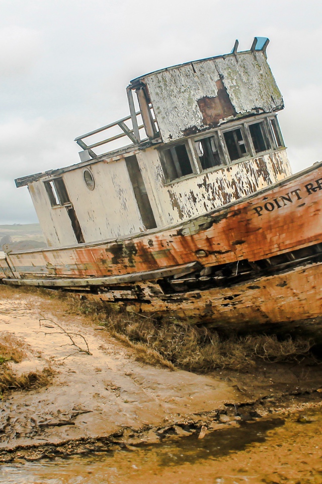 Старая заброшенный рыбацкий баркас на берегу 