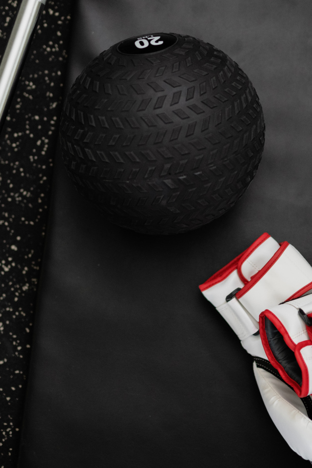 Перчатки и мячик для гольфа лежат в спортзале 