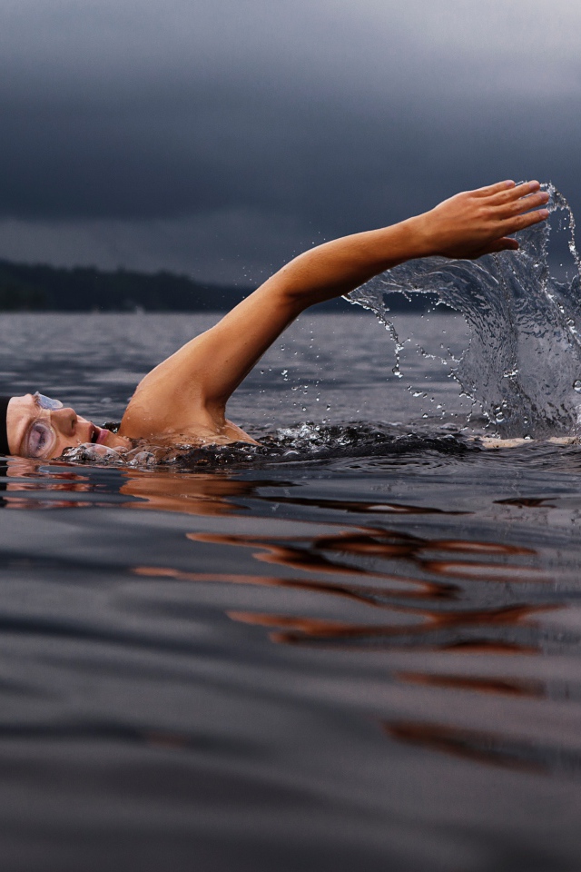 Мужчина пловец в воде озера