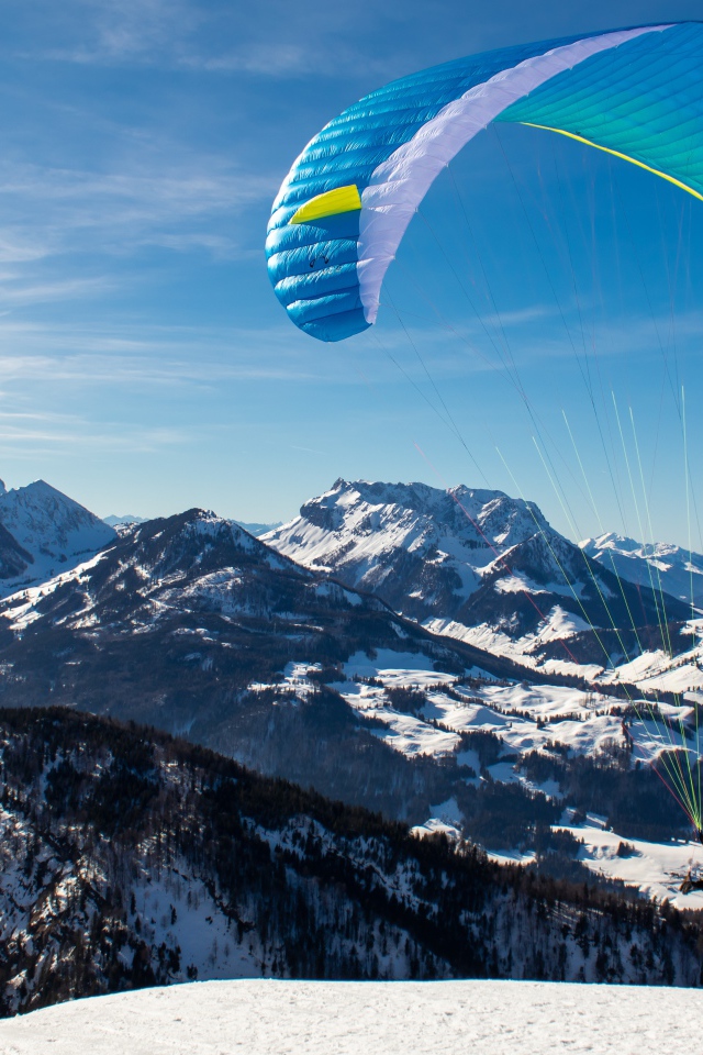 Paraglider jumping from a mountain in winter