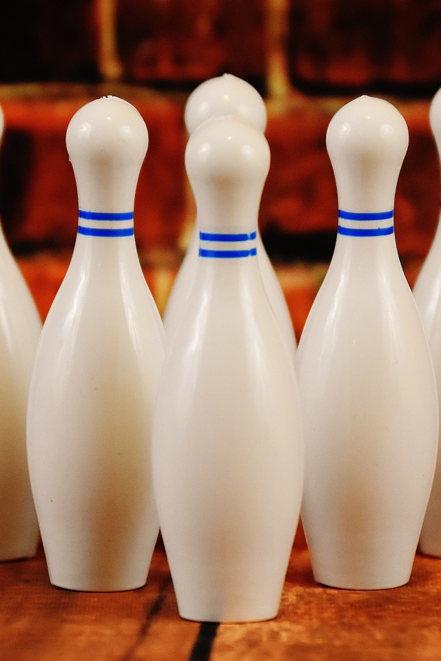 Белые кегли стоят у стены 