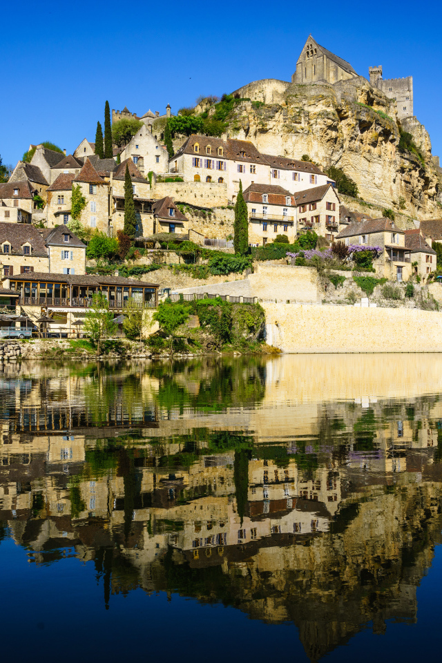 Дома на скале у воды под голубым небом, Франция 