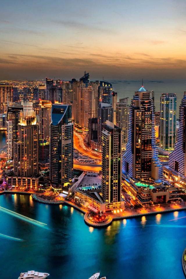 Высокие небоскребы ночного города Дубай у воды 