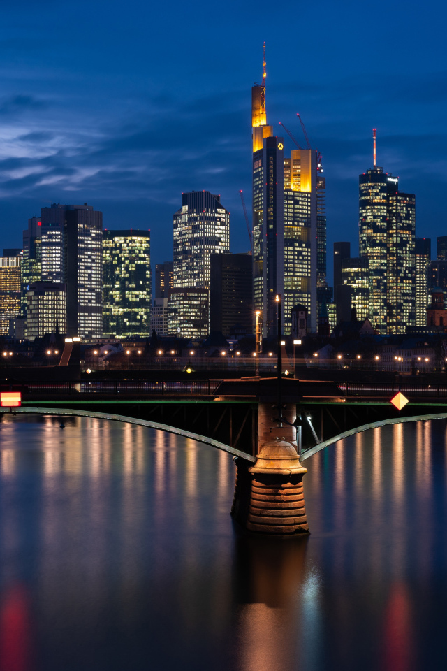 Небоскребы отражаются в воде ночью 