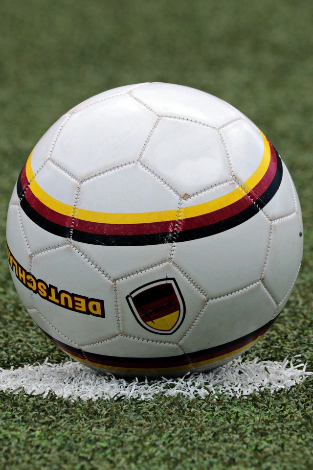 Футбольный мяч лежит на метке на поле 