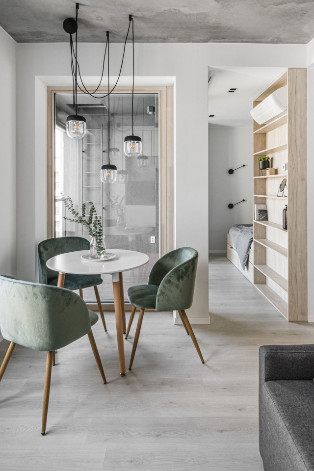 Стол  с креслами стоит у большого окна в квартире 